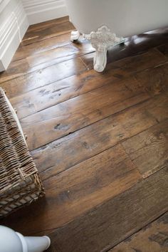 a bathroom with wood flooring and white trim on the walls, along with a wicker basket next to it