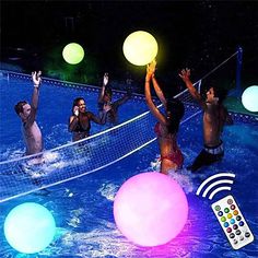 several people playing volleyball in the pool at night