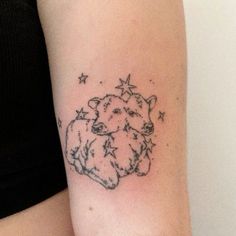 a woman's arm with a small tattoo of a bear and stars on it