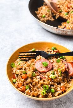 two bowls filled with rice, sausage and peas