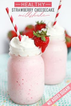 two strawberry milkshakes with strawberries in the background