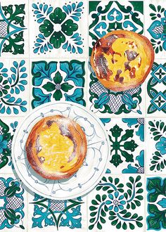 two baked goods sitting on top of a blue and white table cloth with green floral designs