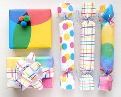 colorful wrapping paper wrapped in different patterns and colors, tied together with twine bows