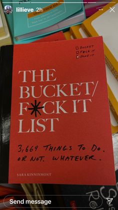 the bucket / fockt list book sitting on top of a pile of books