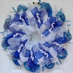 a blue and white mesh wreath hanging on the front door with an anchor in it