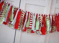 a red, green and white christmas banner hanging from a door with polka dots on it