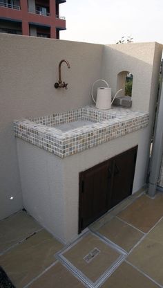 an outdoor kitchen with tiled counter tops and tile backsplashes on the outside wall