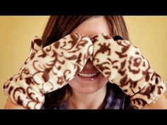 a woman holding her hands up to her face while covering her eyes with leopard print mitts