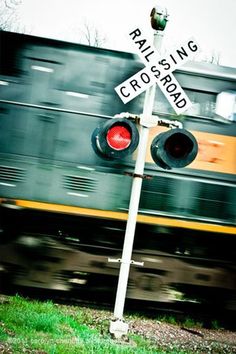 a railroad crossing sign next to a train