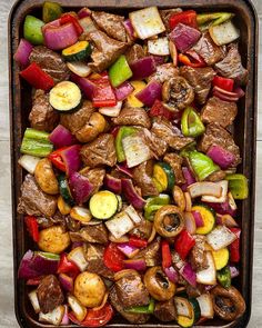 a pan filled with meat and vegetables on top of a table