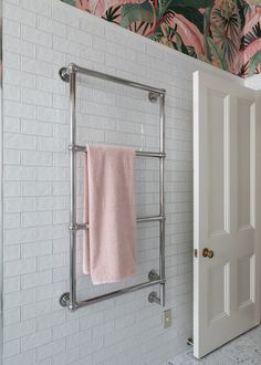 there is a towel rack on the wall in this bathroom with pink towels hanging from it