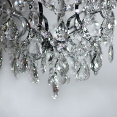 a chandelier hanging from the ceiling with lots of crystal drops on it's sides