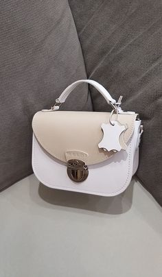 A small white handbag with a light beige lid. Beautiful, charming and very comfortable.  Despite its small size, it is very roomy. Our handbag is made of smooth genuine leather, with a leather lining inside. All edges are processed and painted by hand, making the handbag look neat and expensive. There are two pockets in total inside the bag. The bag closes with a zipper and lock. 🔴You can choose any colors from our palette and make your own unique handbag from them, and we will sew it for you. White Flap Bag With Top Handle For Gift, White Top Handle Flap Bag For Gift, White Top Handle Flap Bag As Gift, White Luxury Satchel Flap Bag, Luxury White Satchel Flap Bag, White Rectangular Flap Bag For Mobile Phone, White Luxury Shoulder Bag With Mobile Phone Holder, White Satchel Shoulder Bag With Mobile Phone Bag, White Crossbody Box Bag Gift