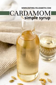 a bottle of cardamom syrup next to a glass cup with seeds on it