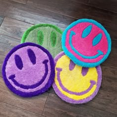 three smiley face rugs sitting on top of a wooden floor