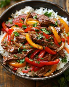 beef and peppers over rice in a bowl on a wooden table with parsley garnish