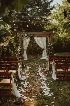 A beautiful backyard wedding setup with a wooden pergola adorned with white drapes, floral arrangements, and a petal-strewn aisle, perfect for inspiring Backyard Wedding Inspiration. Fairytale Country Wedding, Romantic Wedding Theme Ideas, Wedding Detail Ideas, Whimsical Backyard Wedding, Easy Backyard Wedding, Wedding Tulle Decorations, Backyard Wedding Inspiration, Field Wedding Ideas, Outdoor Venue Wedding