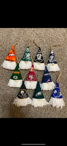 the nfl christmas ornaments are lined up in different colors and sizes, with tassels attached to them