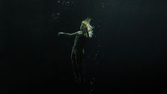 a woman floating in the water with her arms outstretched