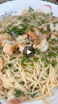 a white plate topped with pasta and shrimp