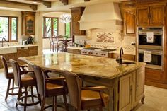 a large kitchen with an island in the middle and lots of counter space on one side