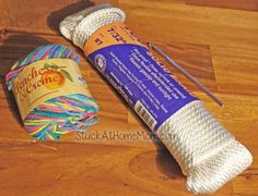 two skeins of yarn next to a crochet hook on a wooden floor