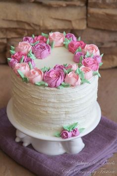 a white cake with pink and purple flowers on it