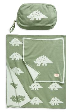 a green blanket with white trees on it and two matching blankets, one is folded to the side