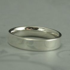 a close up of a wedding ring on a table with a white surface in the background