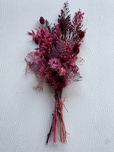 a bunch of dried flowers sitting on top of a white surface