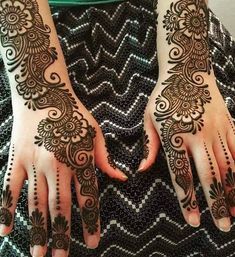 two hands with henna tattoos on them