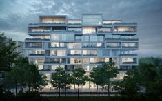 an apartment building with many balconies and trees in front of it at dusk