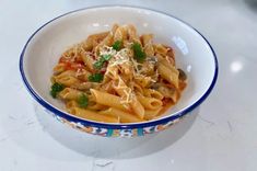 a bowl filled with pasta and sauce on top of a table