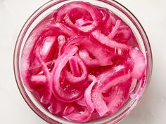 a glass bowl filled with sliced red onions