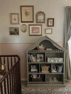 a baby's room with a crib, bookshelf and pictures on the wall