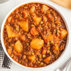 a white bowl filled with stew on top of a table