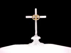 two wedding rings on top of a cross