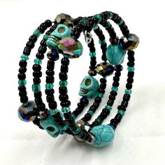 This Black And Teal Memory Wire Wrap Bracelet Is Made With Czech Fire Polished Beads, Dark Iris Rainbow Ab Crystals, And Turquoise Candy Skull Beads For An Awesome Piece Of Arm Candy! Black Skull Bracelets For Festival, Adjustable Handmade Skull Bracelets, Adjustable Black Stretch Bracelet For Festivals, Handmade Bohemian Bracelets For Halloween, Bohemian Handmade Bracelets For Halloween, Black Hand Wrapped Beaded Bracelets For Festival, Hand Wrapped Black Beaded Bracelets For Festivals, Festival Hand-wrapped Black Beaded Bracelets, Black Jewelry For Day Of The Dead Gift