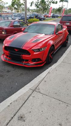 a red and black mustang parked in a parking lot