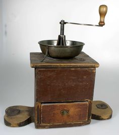 an old wooden box with a metal bowl on top