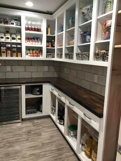 a kitchen with white cabinets and shelves filled with food