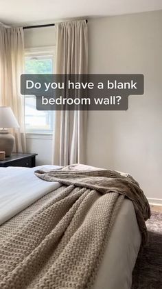 a bed with a blanket on top of it next to a window