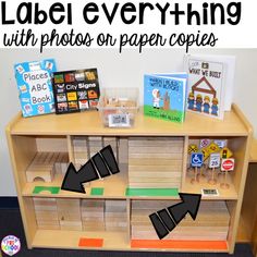 a wooden table topped with lots of books and paper cut outs on top of it