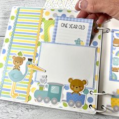 a hand is holding an open planner book with baby pictures on it and teddy bears