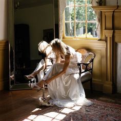 a woman sitting on the floor in front of a mirror