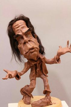 a sculpture of a man with long hair on top of a table