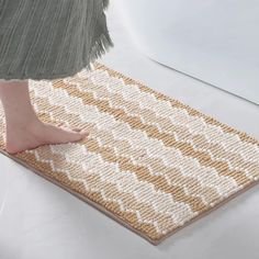 a close up of a person's feet on a mat with an area rug