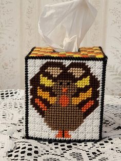 a tissue dispenser made out of plastic beads with an image of a turkey on it