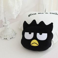 an angry bird pillow sitting on top of a white table next to a candle holder