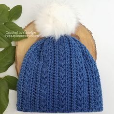 a blue knitted hat with a white pom - pom